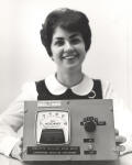 This Aerosol Particle Analyzer, being displayed by Theresa Thibodeau of the Instrumentation Laboratory, was flown on one of the Apollo earth orbital flights. The device measured content of microscopic bits of solid of liquid matter in the spaceship cabin for possible effect on the well-being of the astronaut or the reliability of the electronic equipment. 