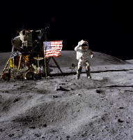 Astronaut John W. Young, commander of the Apollo 16 lunar landing mission, jumps up from the lunar surface as he salutes the U.S. Flag at the Descartes landing site during the first Apollo 16 extravehicular activity (EVA-1). Astronaut Charles M. Duke Jr., lunar module pilot, took this picture. The Lunar Module (LM) "Orion" is on the left. The Lunar Roving Vehicle is parked beside the LM. The object behind Young in the shade of the LM is the Far Ultraviolet Camera/Spectrograph. Stone Mountain dominates the background in this lunar scene. 